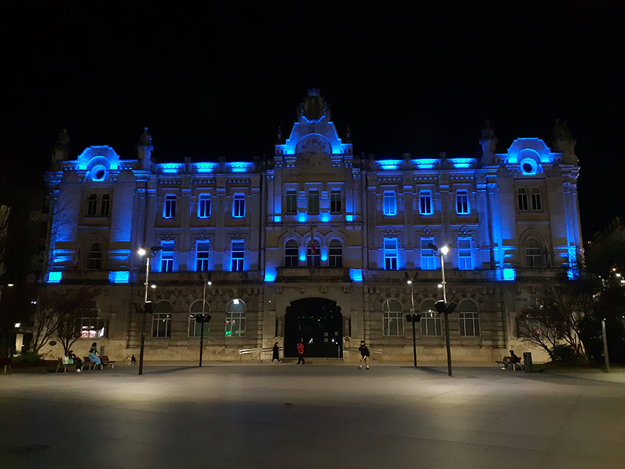 Edificio histórico de Cantabria iluminado con el color azul de la Policía Nacional.